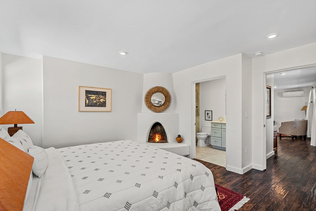 Cozy up in your stylish bedroom featuring a crackling fireplace, perfect for romantic evenings after exploring the area.