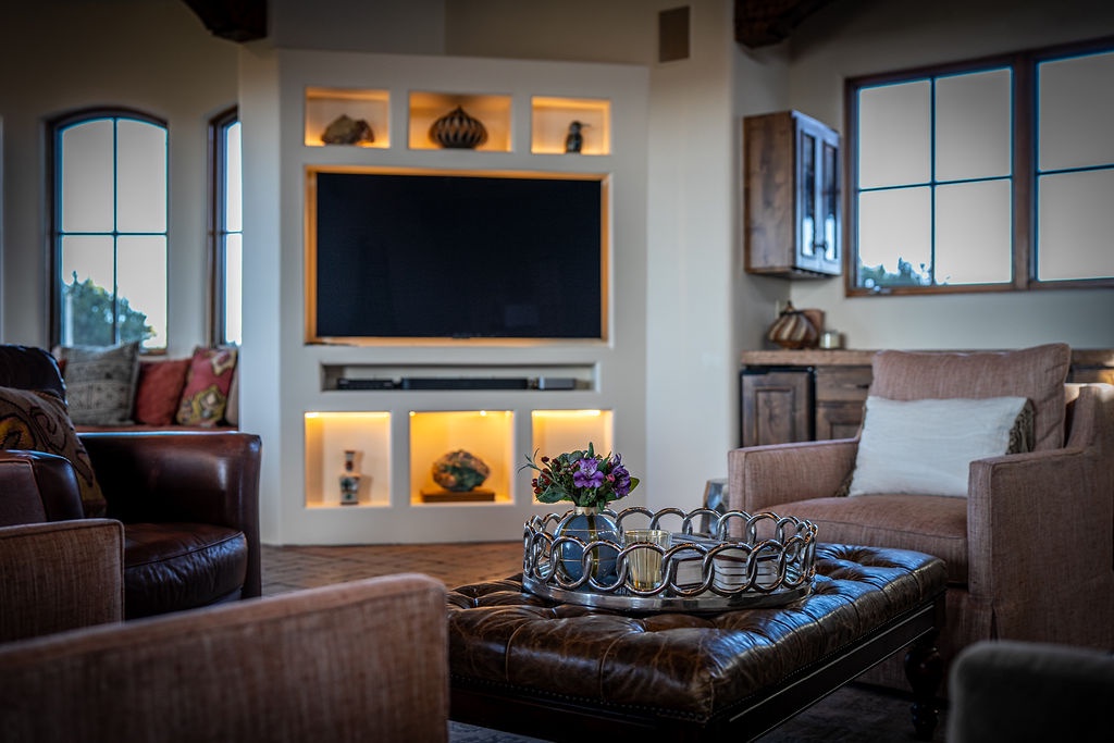 Sink into rich leather seating while warm light dances across the built-in entertainment center, creating your perfect evening retreat.