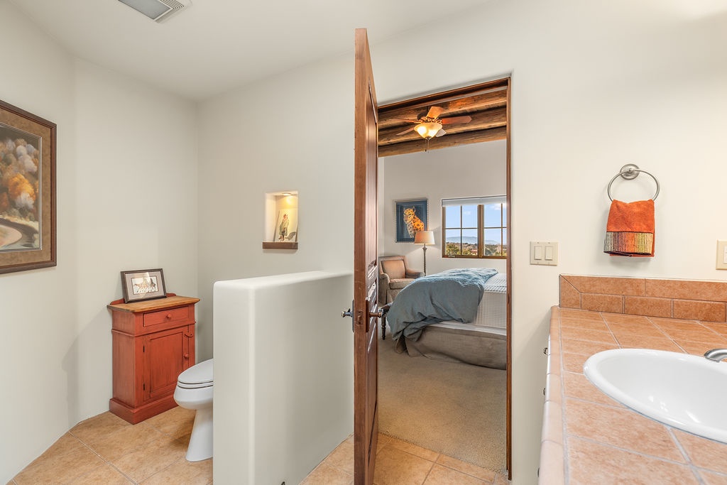 Your private en-suite bathroom features warm wood accents and a convenient walk-through shower connecting to your bedroom.