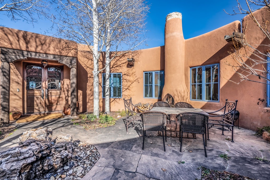 Charming adobe-style property features a welcoming private courtyard with outdoor dining space surrounded by traditional southwestern architecture.