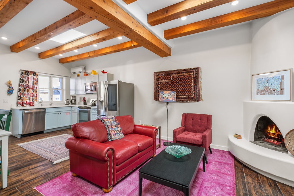 Cozy up by your crackling fireplace in this vibrant living space with exposed beams, red leather seating, and fully equipped kitchen.