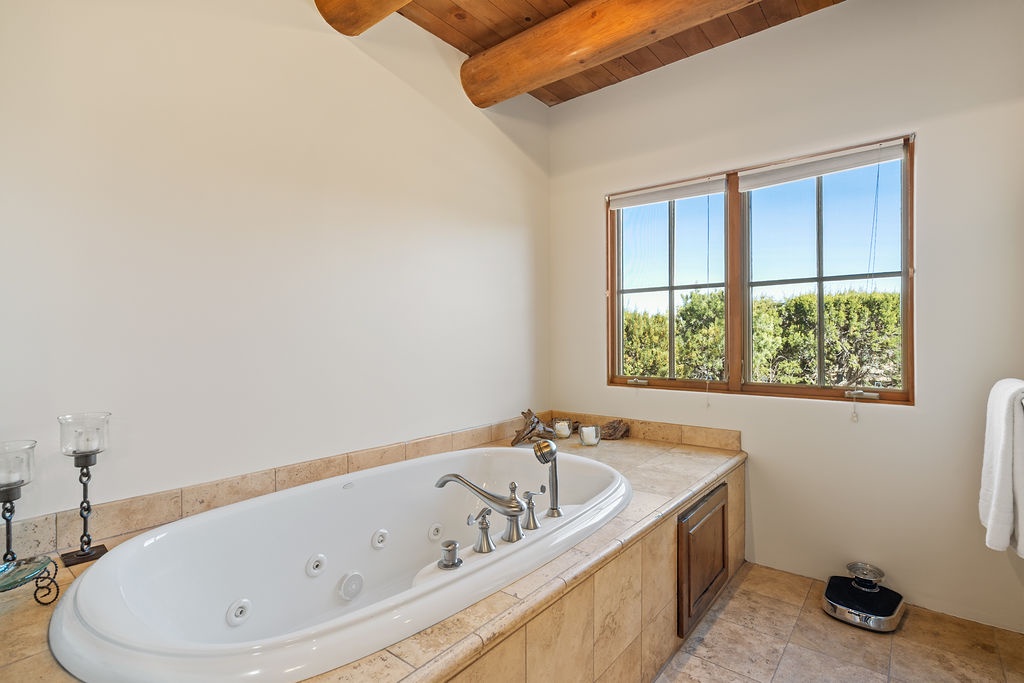 Soak in your private jetted tub surrounded by rustic wood beams while gazing at peaceful nature views through the window.
