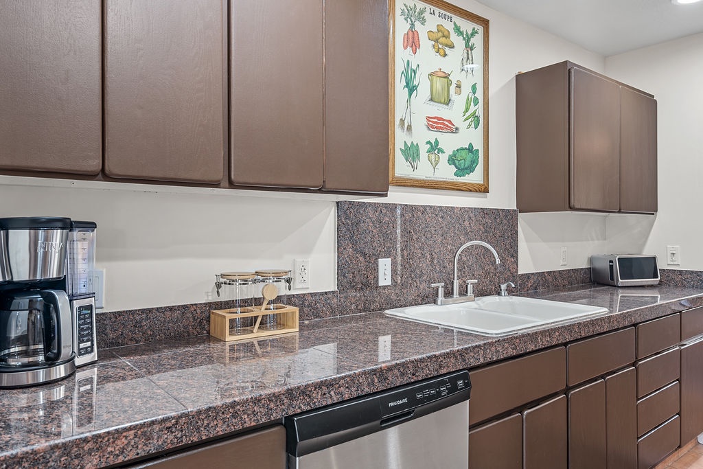 Your fully equipped kitchen features granite countertops, modern appliances, and charming botanical artwork to inspire your culinary adventures.