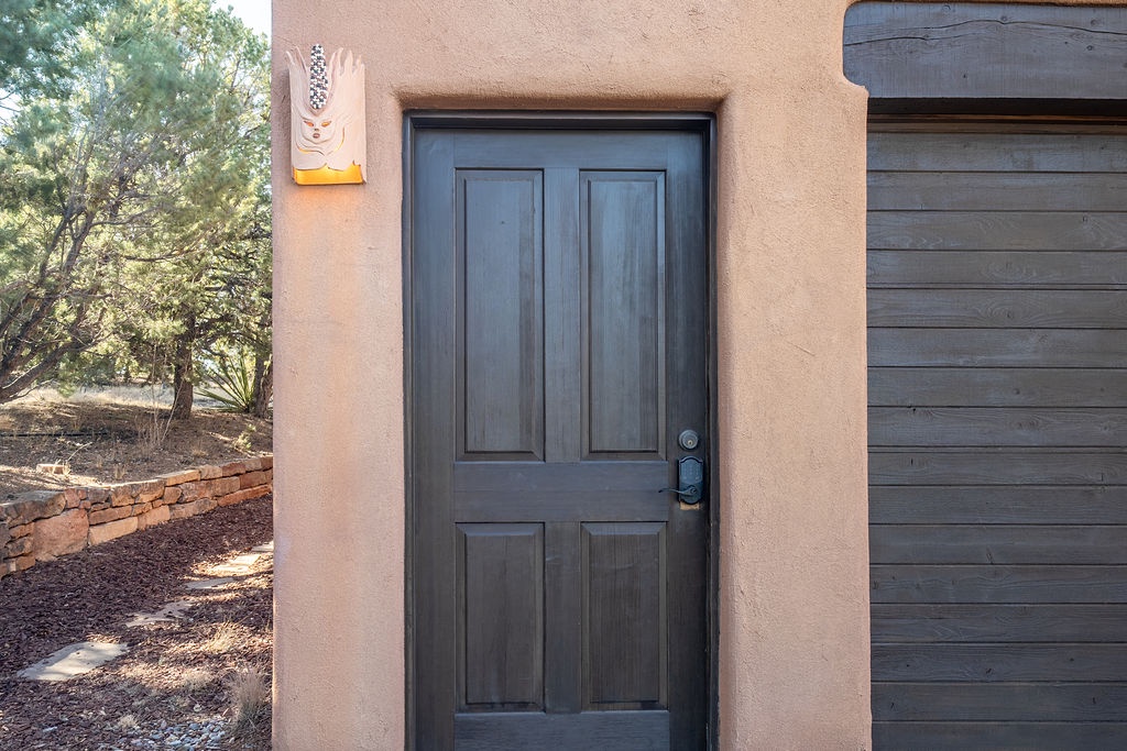Charming desert-style property entrance with artistic southwestern accents and natural landscaping creates a welcoming arrival experience.