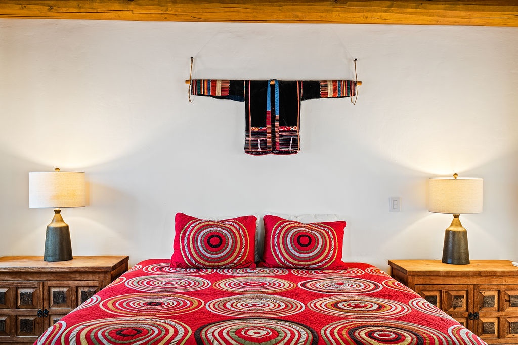 Relax in your cozy bedroom featuring vibrant textiles, warm wooden beams, and authentic cultural artwork that creates a truly unique atmosphere.