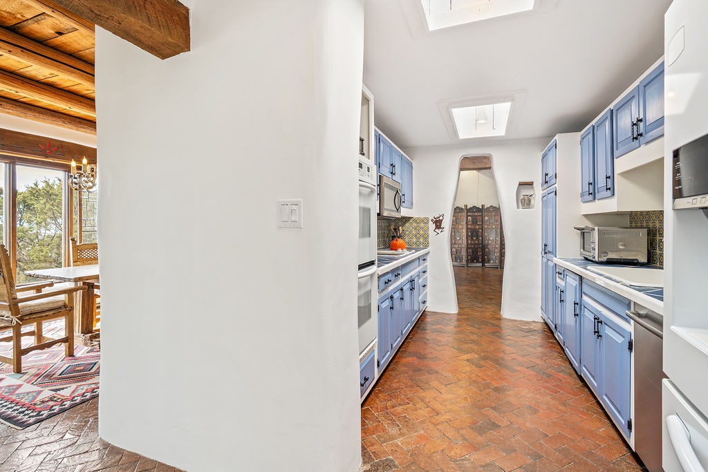 Your spacious galley kitchen features charming blue cabinets and terracotta floors, perfect for preparing memorable meals during your stay.