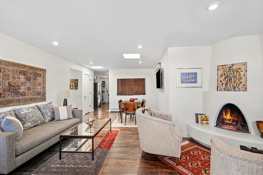 Relax in your stylish living space featuring comfortable seating, warm fireplace, and beautiful artwork for cozy evenings together.