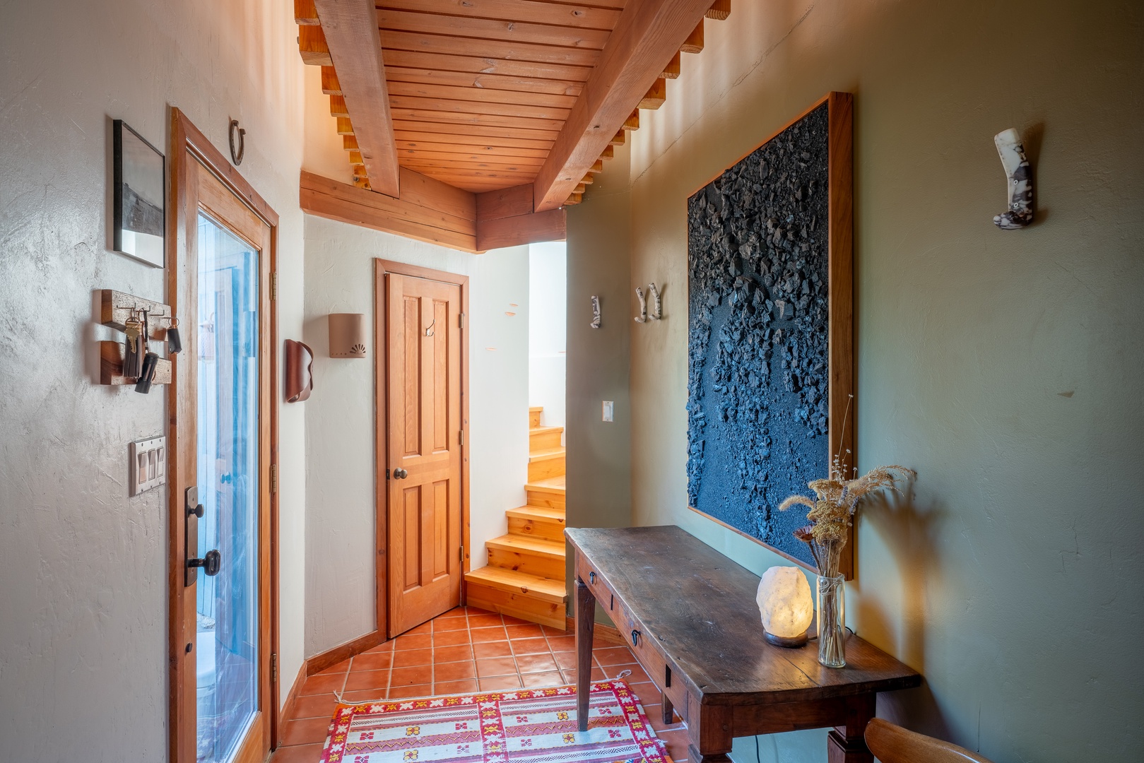 Step into your welcoming entrance, where warm wood beams, curated art, and thoughtful design create an inviting first impression that feels like home.