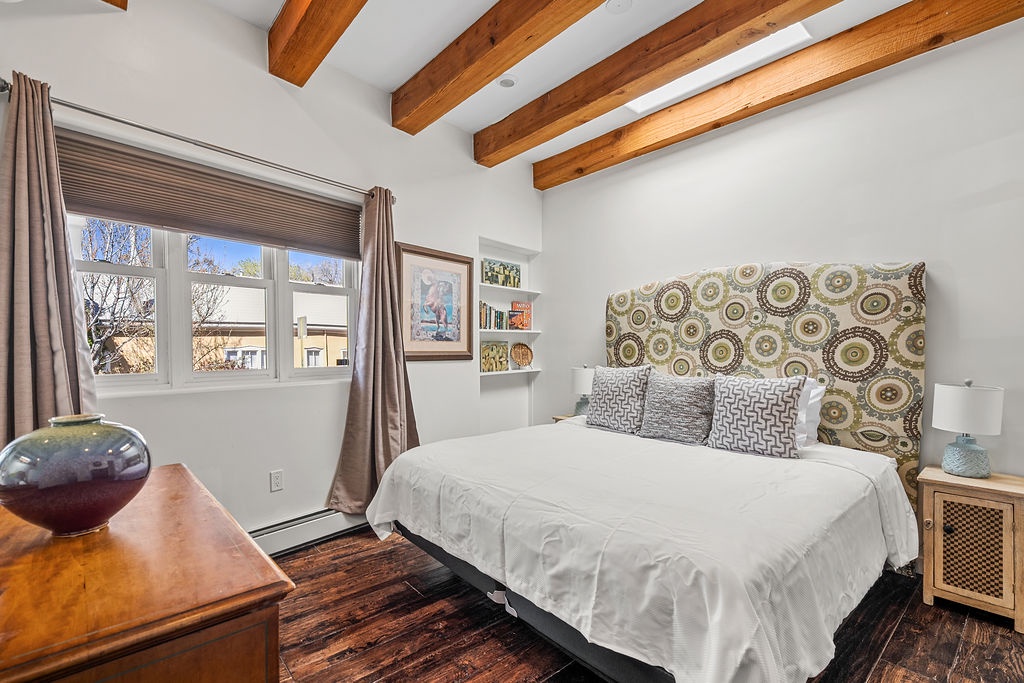 Rest peacefully under rustic wooden beams in your cozy bedroom, where stylish furnishings and soft natural light create the perfect retreat.