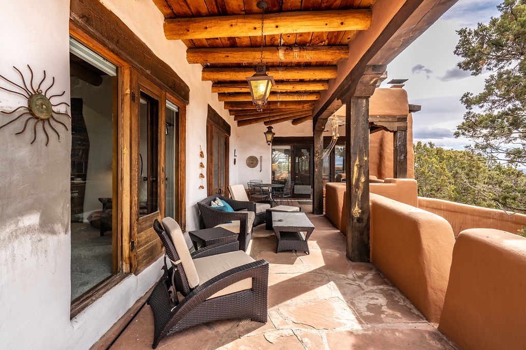 Unwind on your private terrace with rustic vigas overhead, comfortable seating, and stunning forest views stretching to the horizon.