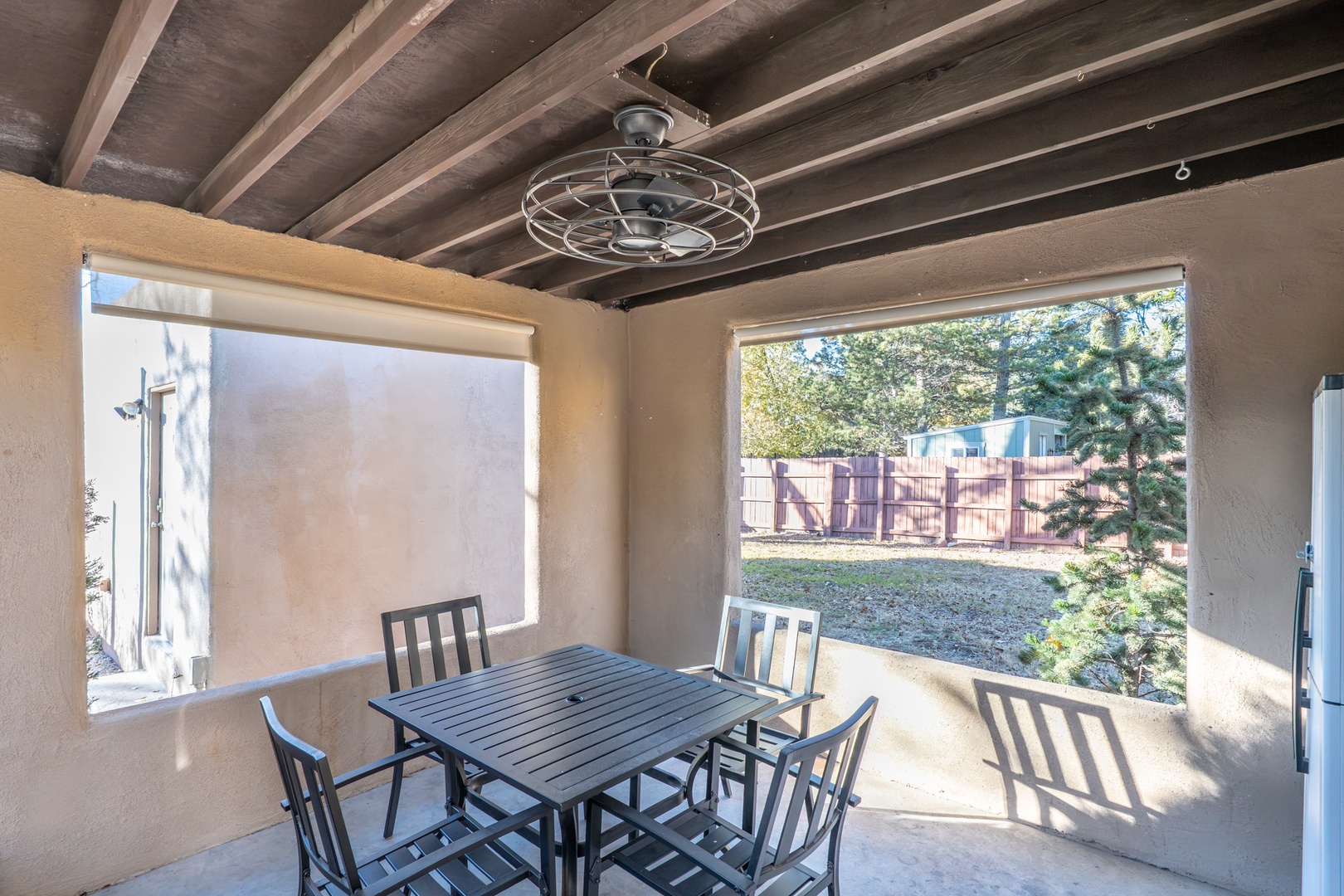 Your covered patio dining space features exposed beam ceilings and overlooks the peaceful backyard, perfect for enjoying meals outdoors year-round.