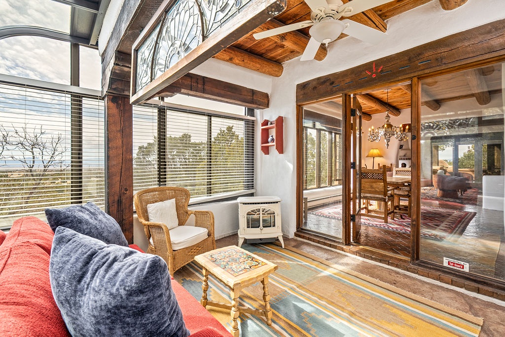 Relax in your sun-drenched living space with exposed beams, cozy seating, and panoramic views stretching to distant mountains.