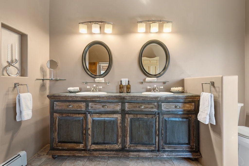 Luxurious double vanity with rustic charm awaits your morning routine, featuring elegant mirrors and ambient lighting for your comfort.