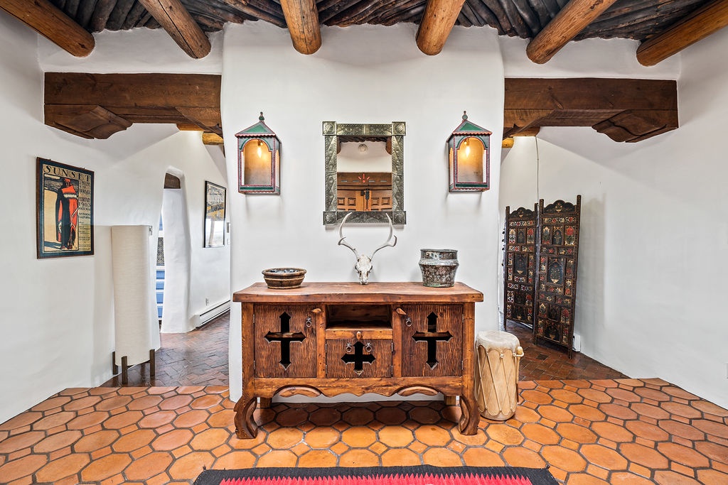 Step into your charming southwestern retreat, where rustic wooden beams frame authentic handcrafted furnishings and warm terracotta tiles beneath your feet.