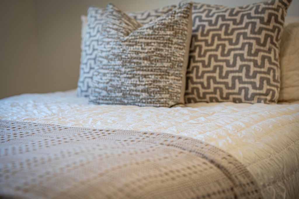 Sink into this perfectly made bed with plush textured pillows and soft linens waiting for your restful night's sleep.