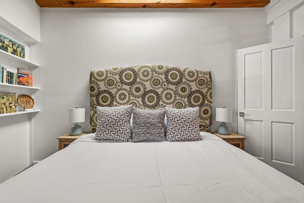 Your peaceful bedroom retreat features rustic wood beams overhead and thoughtful details like built-in bookshelves for cozy reading nights.