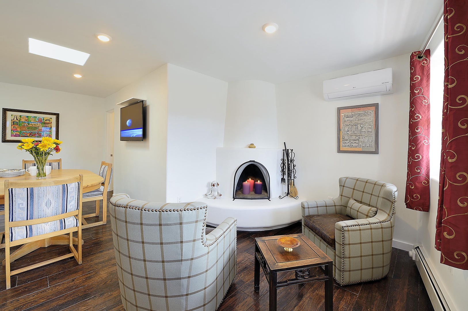Relax by your cozy fireplace with plaid chairs, dining table, and modern amenities for a perfect getaway.