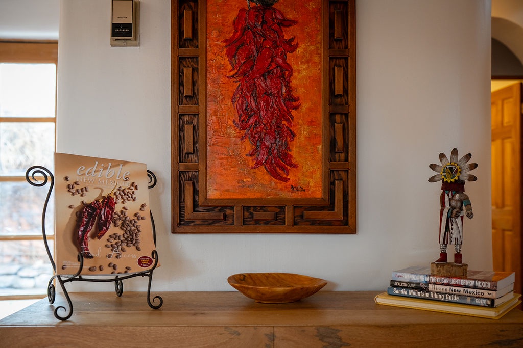Discover authentic Southwestern charm with vibrant red chile artwork, handcrafted ceramics, and Native American treasures adorning your cozy retreat.