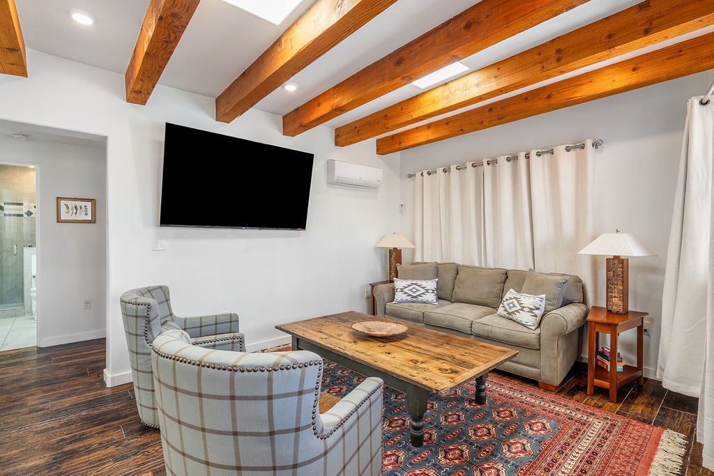 Unwind in your stylish living room with exposed beams, comfy seating, and modern amenities for the perfect mountain getaway.
