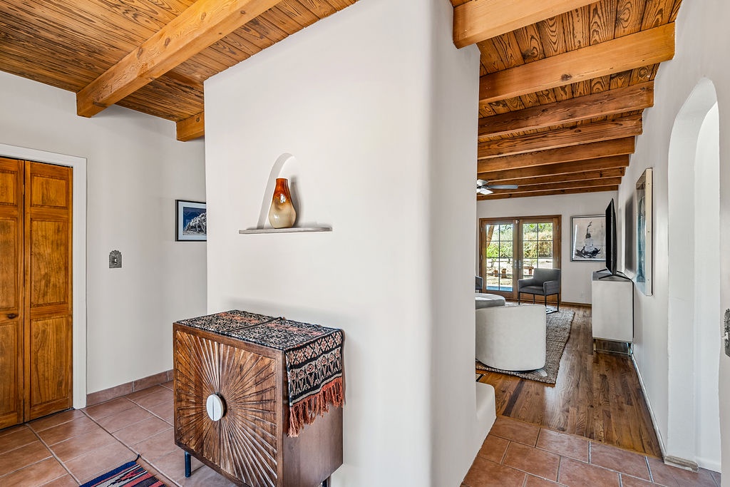 Step into your charming Southwest retreat where warm wood beams frame white adobe walls, creating a perfect blend of rustic elegance and modern comfort.