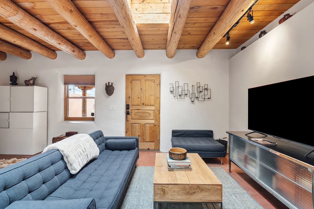 Relax in this stylish living space with exposed wood beams overhead and modern blue sectional seating perfect for unwinding after your adventures.
