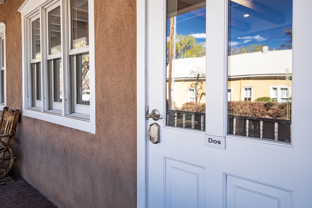 Your private entrance welcomes you with gleaming glass doors that frame charming neighborhood views, setting the stage for your peaceful getaway.