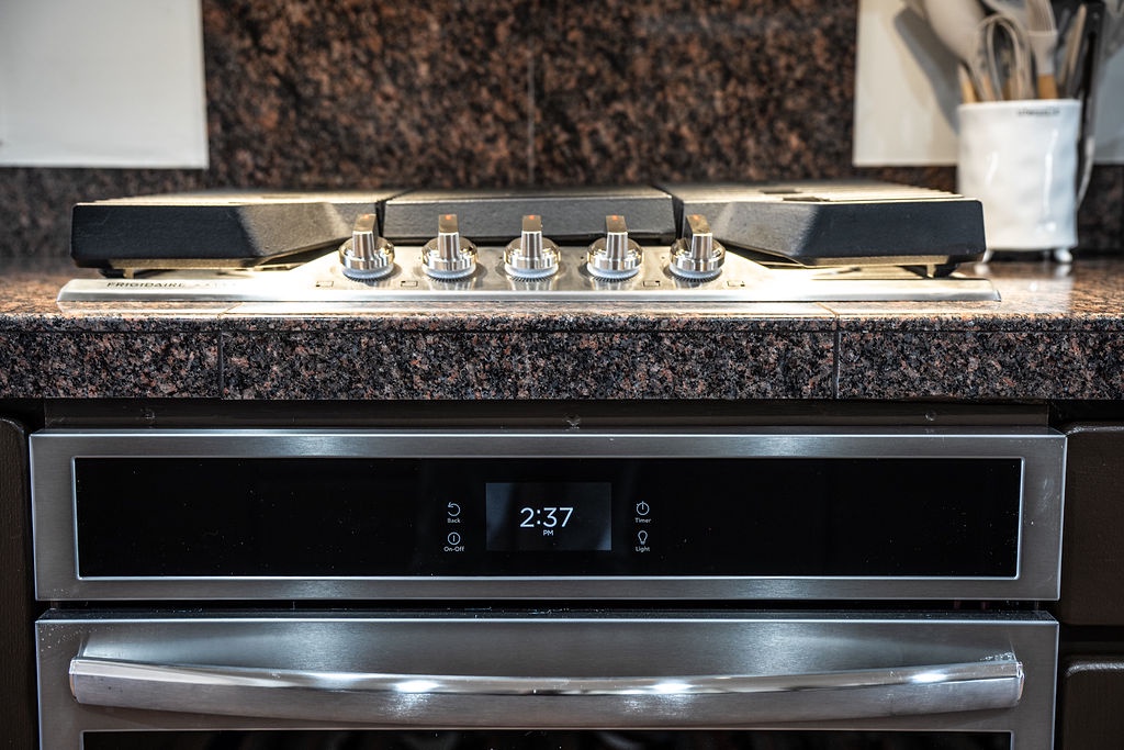 Your sleek gas cooktop sits perfectly on granite counters, ready for your culinary adventures with precise temperature control.