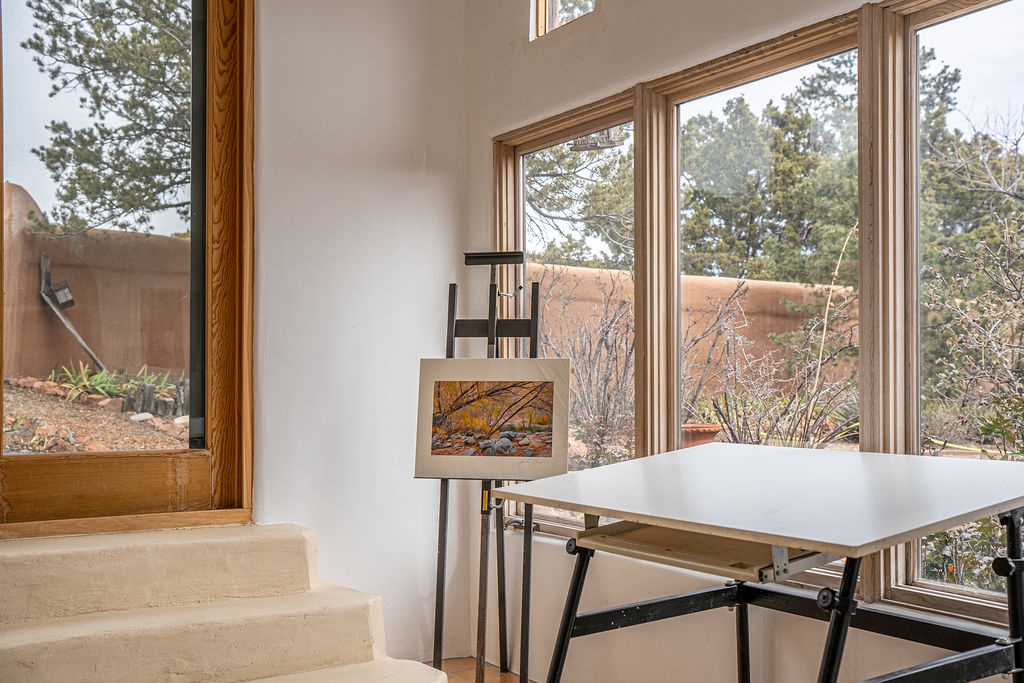 Settle into your sun-drenched creative corner, where art meets inspiration surrounded by stunning natural views through floor-to-ceiling windows.