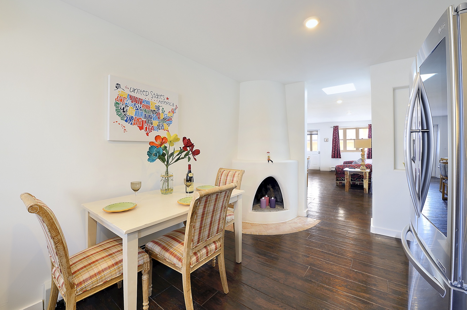 Gather around this cozy dining nook where you'll share meals by a charming kiva fireplace, with modern kitchen convenience just steps away.