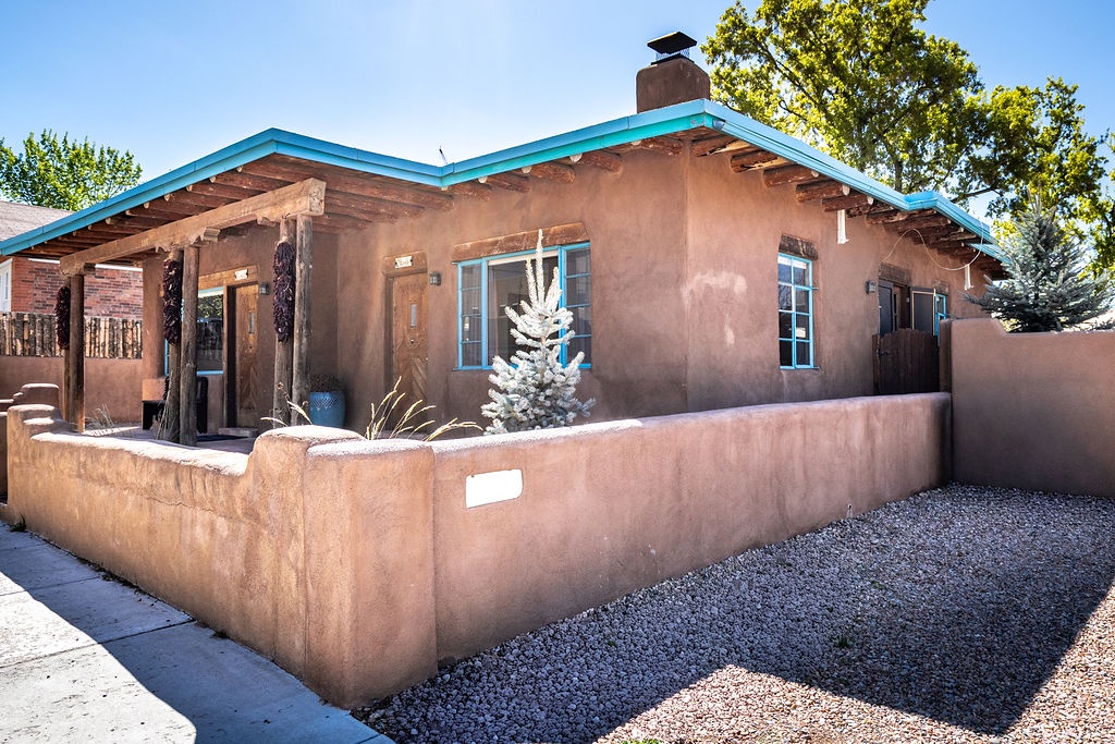 Charming adobe-style property featuring turquoise accents and authentic Southwestern architecture in a peaceful residential setting.