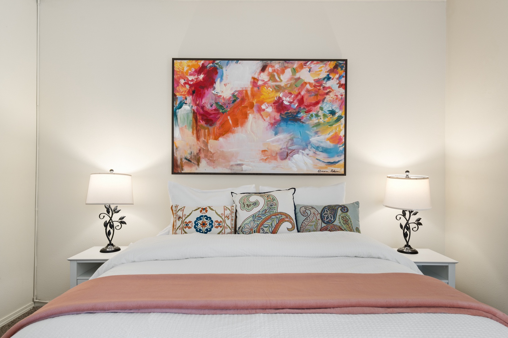 Rest peacefully in your stylish bedroom featuring a comfortable bed, vibrant artwork, and thoughtful lighting that creates the perfect ambiance for relaxation.