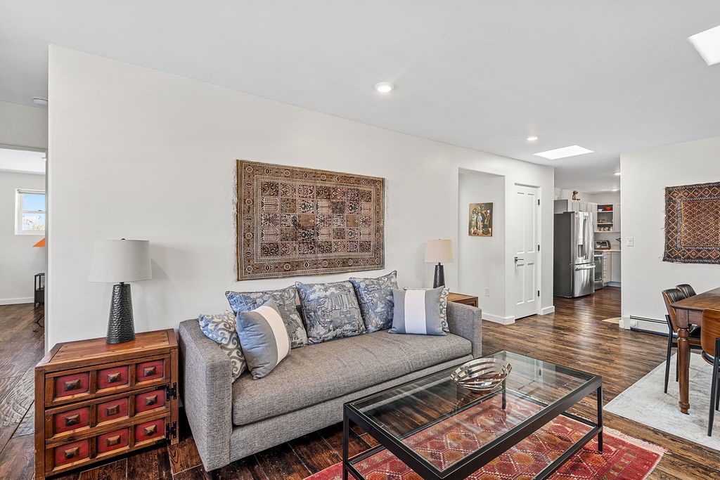 Unwind in your stylish living room featuring a plush sofa, warm hardwood floors, and curated artwork that creates the perfect atmosphere for relaxation.