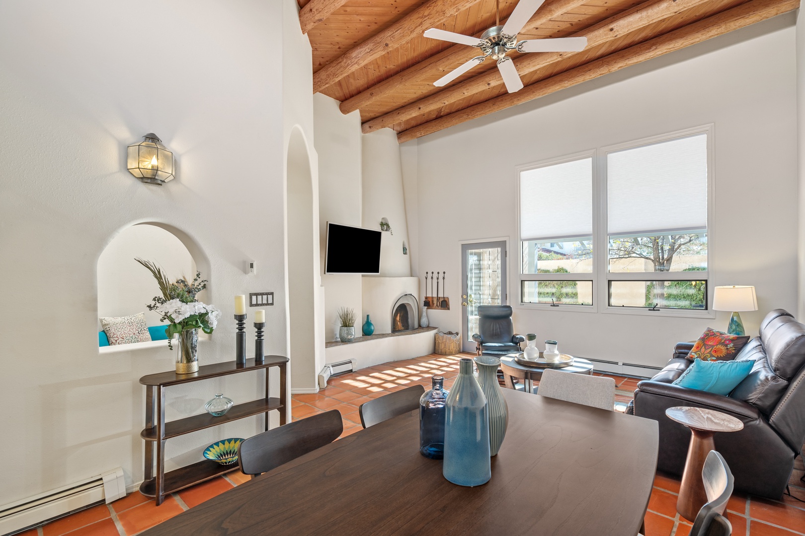 Relax in your beautiful living room featuring exposed wood beam ceilings, a cozy fireplace, and comfortable seating where you can unwind after exploring the area.