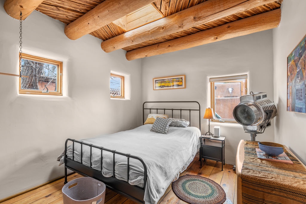 Drift into peaceful sleep beneath handcrafted wooden beams, where vintage charm meets modern comfort in your cozy bedroom retreat.