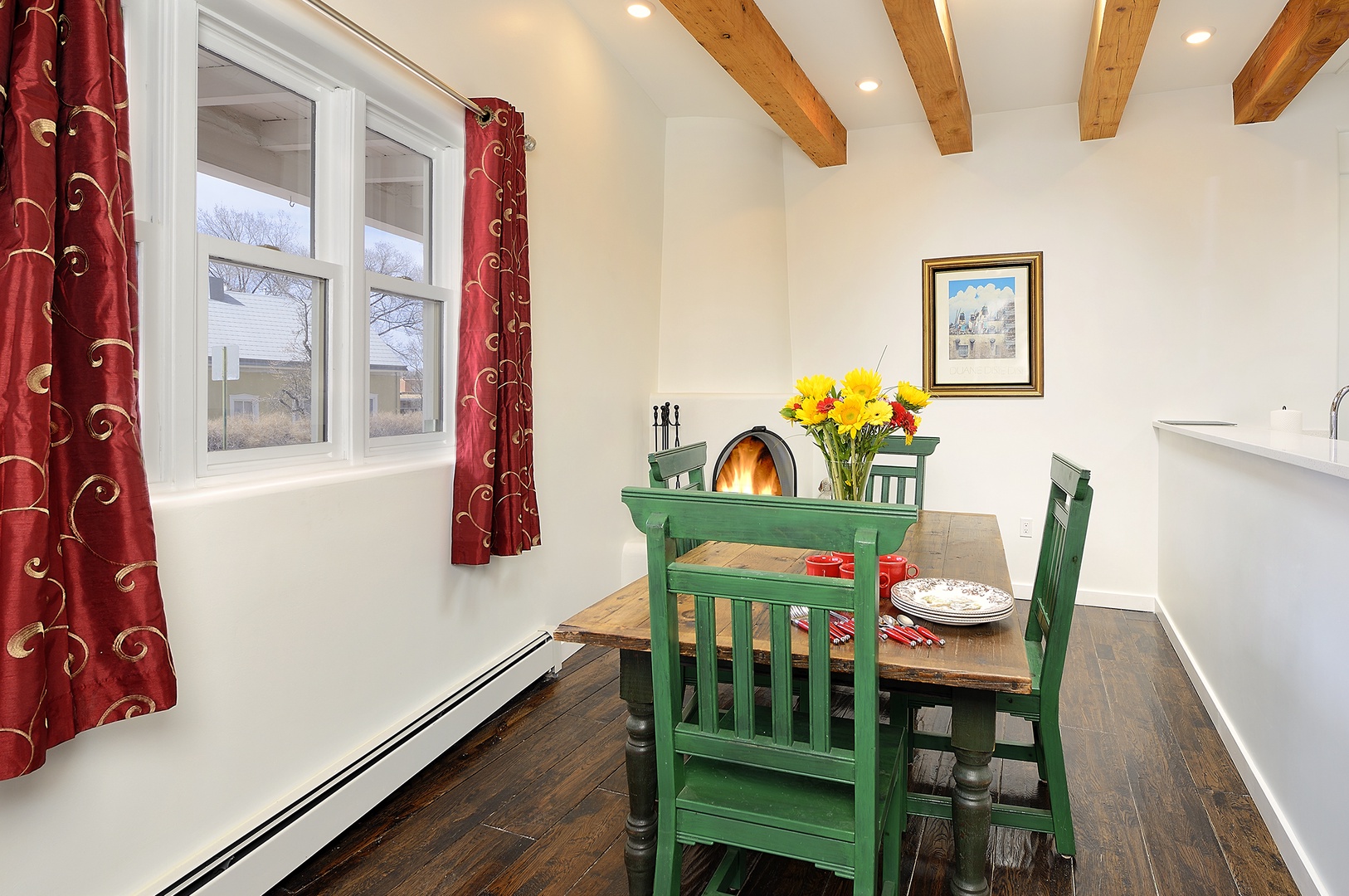 Gather around your charming dining table beneath rustic beams, where fresh flowers and warm light create perfect moments for memorable meals.
