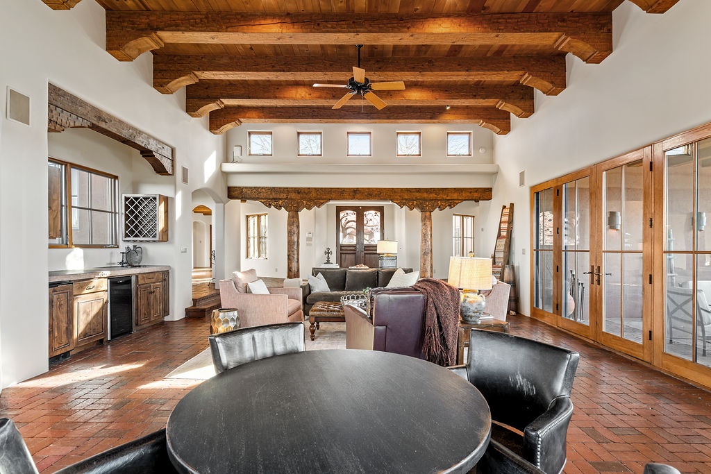 You'll love gathering in this stunning open-concept living space with soaring wood beam ceilings and warm southwestern charm.