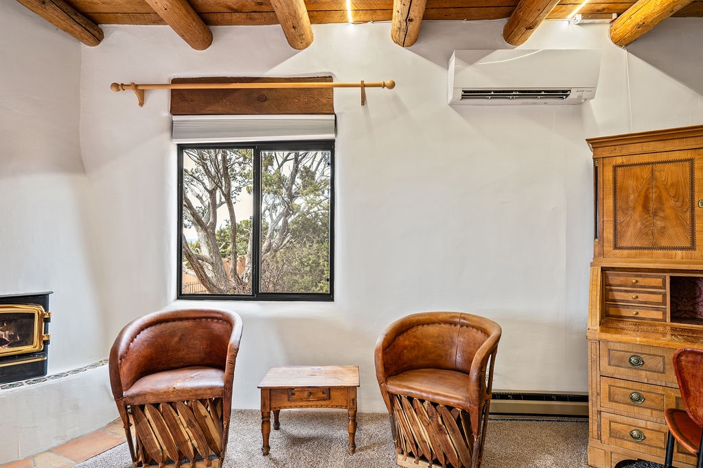 Relax in this cozy corner with rustic charm, featuring handcrafted leather chairs beneath beautiful exposed wooden beams.
