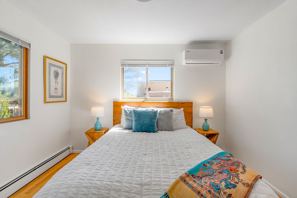 Wake up refreshed in your comfortable bedroom with plush bedding, warm wood furnishings, and peaceful natural light streaming through your windows.