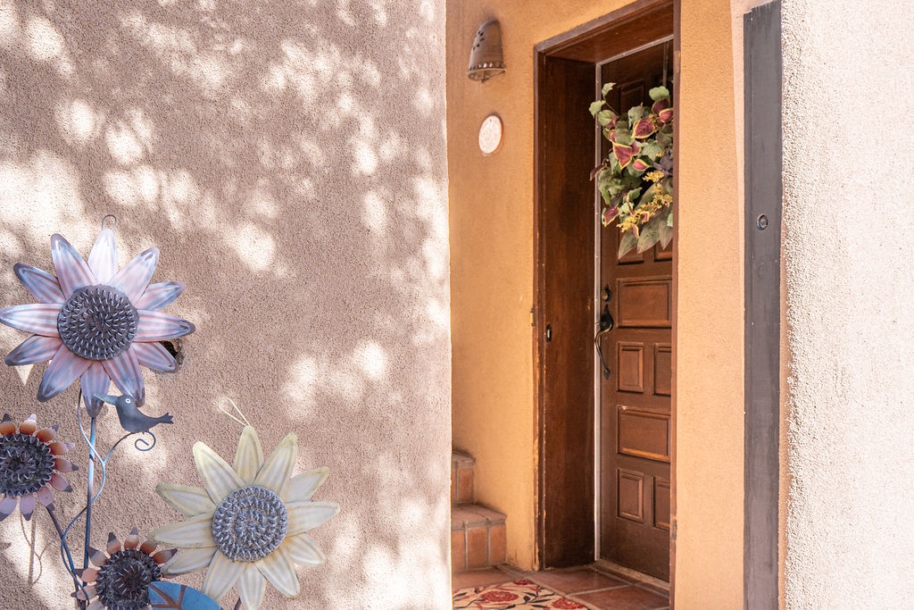 Charming entrance with warm adobe walls and decorative sunflowers welcomes you to your southwestern retreat.