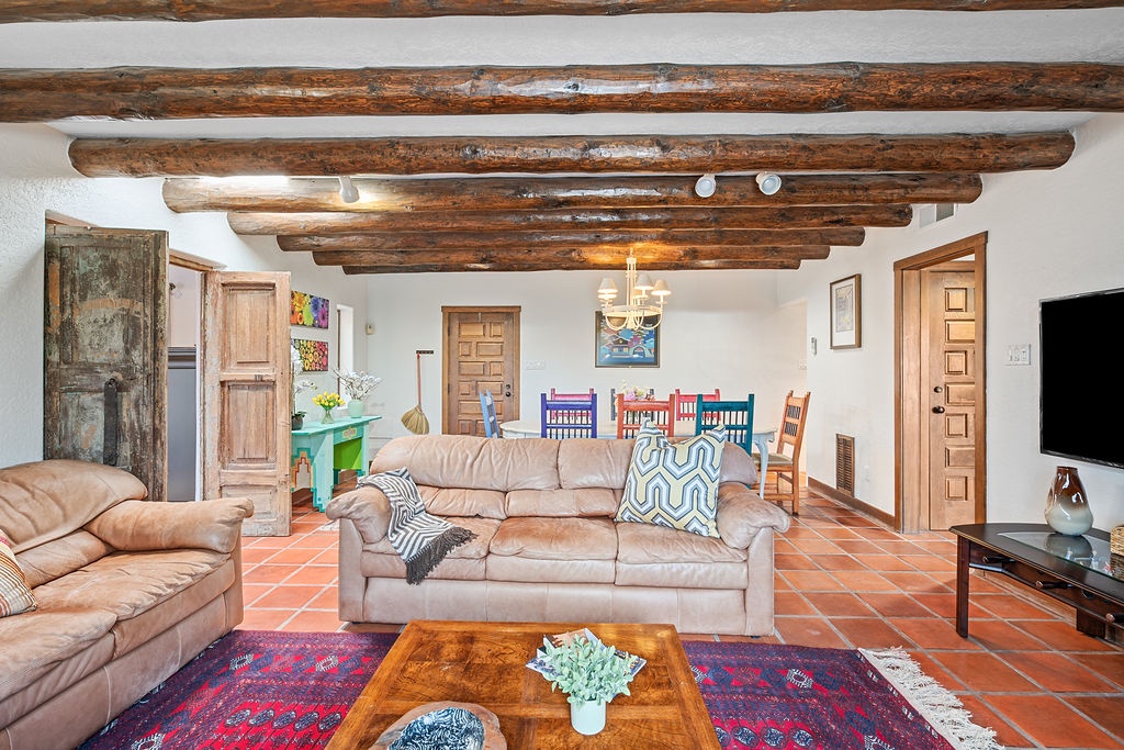 Relax in your spacious living room where rustic exposed beams meet modern comfort. Sink into plush leather sofas and enjoy cozy evenings.