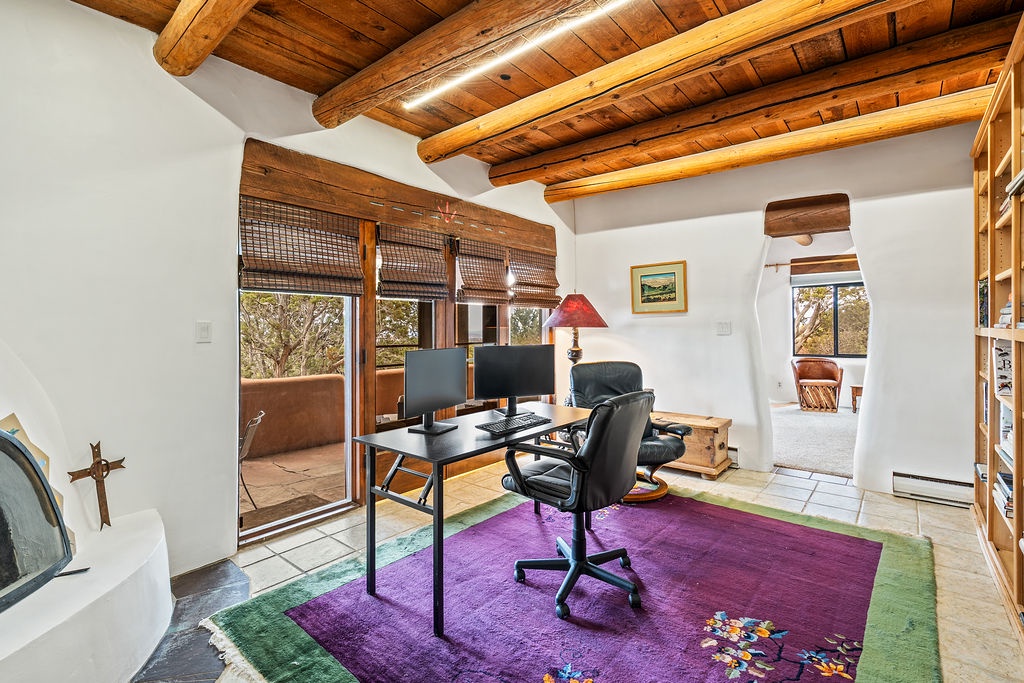 Your private workspace features rustic wooden beams and a comfortable desk setup where you can stay productive while enjoying peaceful garden views.