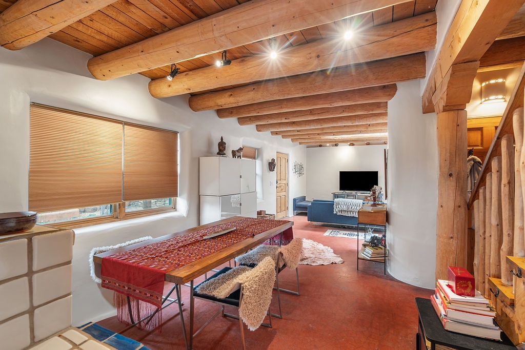 Unwind beneath stunning wood beams in this spacious living area where rustic charm meets modern comfort for your perfect getaway.