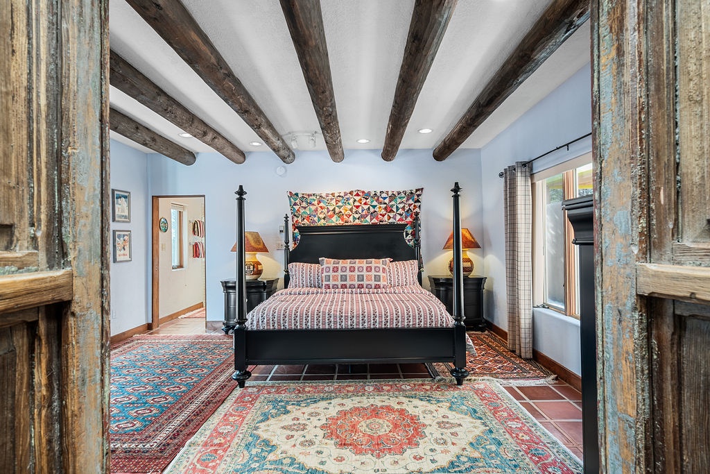 Drift off in your elegant four-poster bed beneath rustic wooden beams, wrapped in vibrant quilts and surrounded by charming folk art touches.