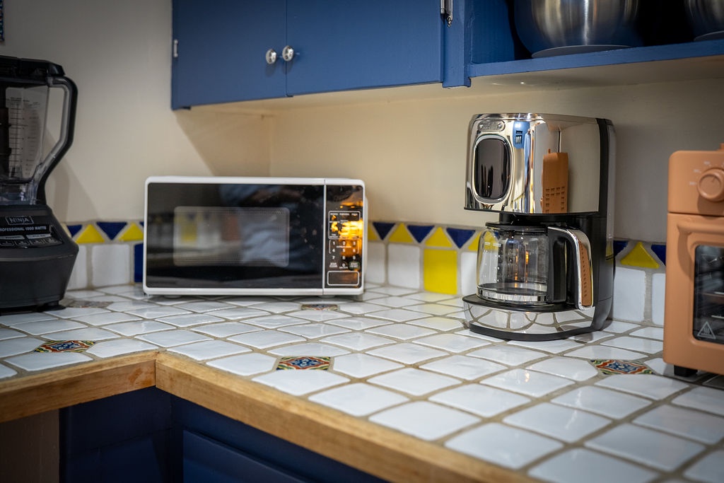 Your well-equipped kitchen features modern appliances and cheerful tile work, perfect for brewing morning coffee or preparing meals.