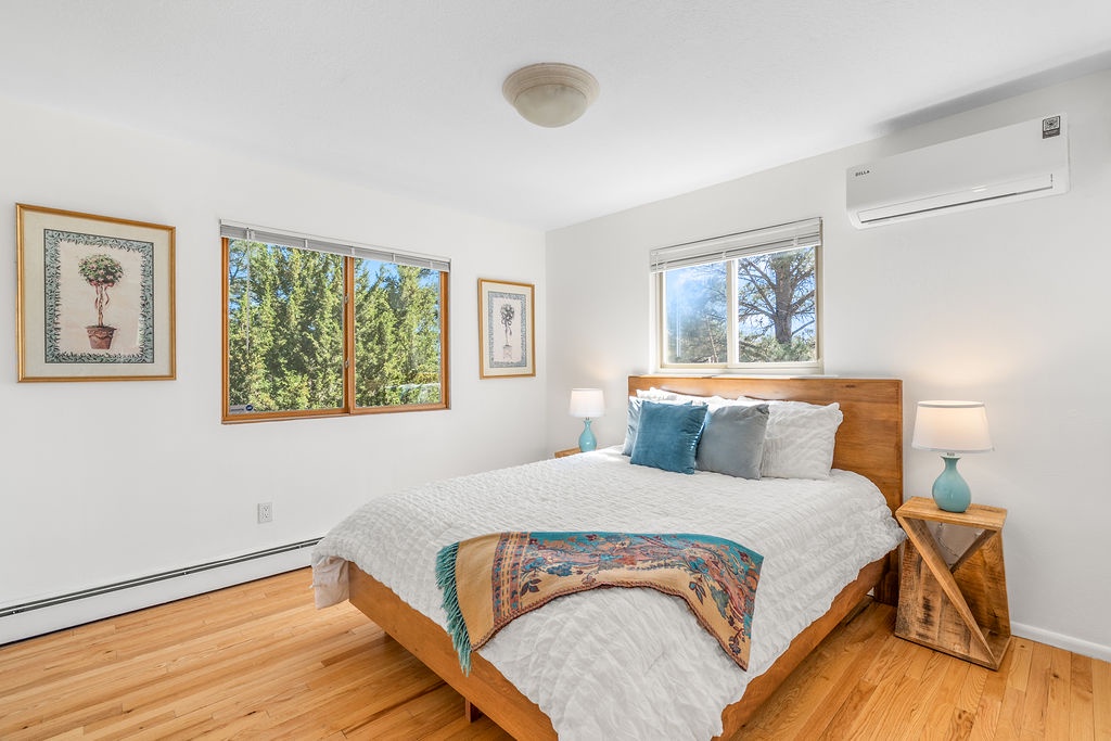 Wake to natural light streaming through your bedroom windows, where warm wood tones and peaceful garden views create your perfect retreat.