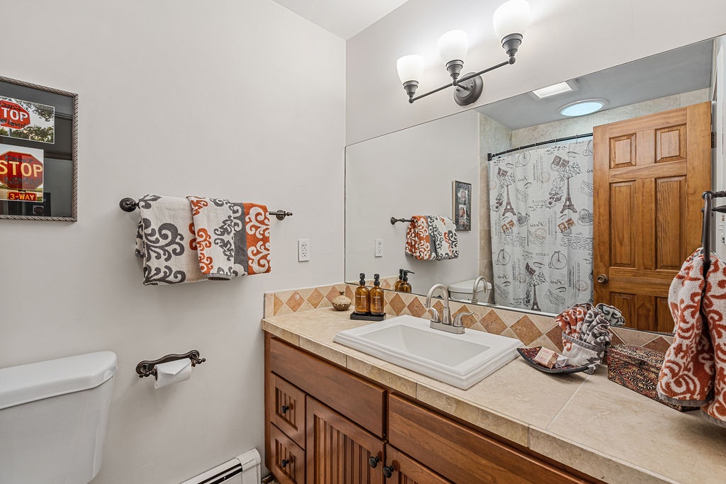 Your private bathroom features warm wood vanity, stylish tilework, and thoughtful touches that make your morning routine feel like home.