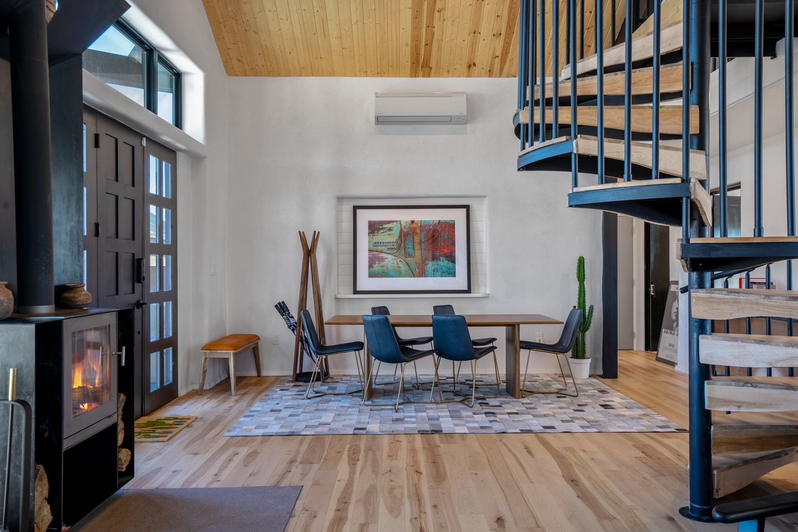 Gather around this striking dining table beneath soaring wooden ceilings, warmed by the crackling fireplace and natural light streaming in.