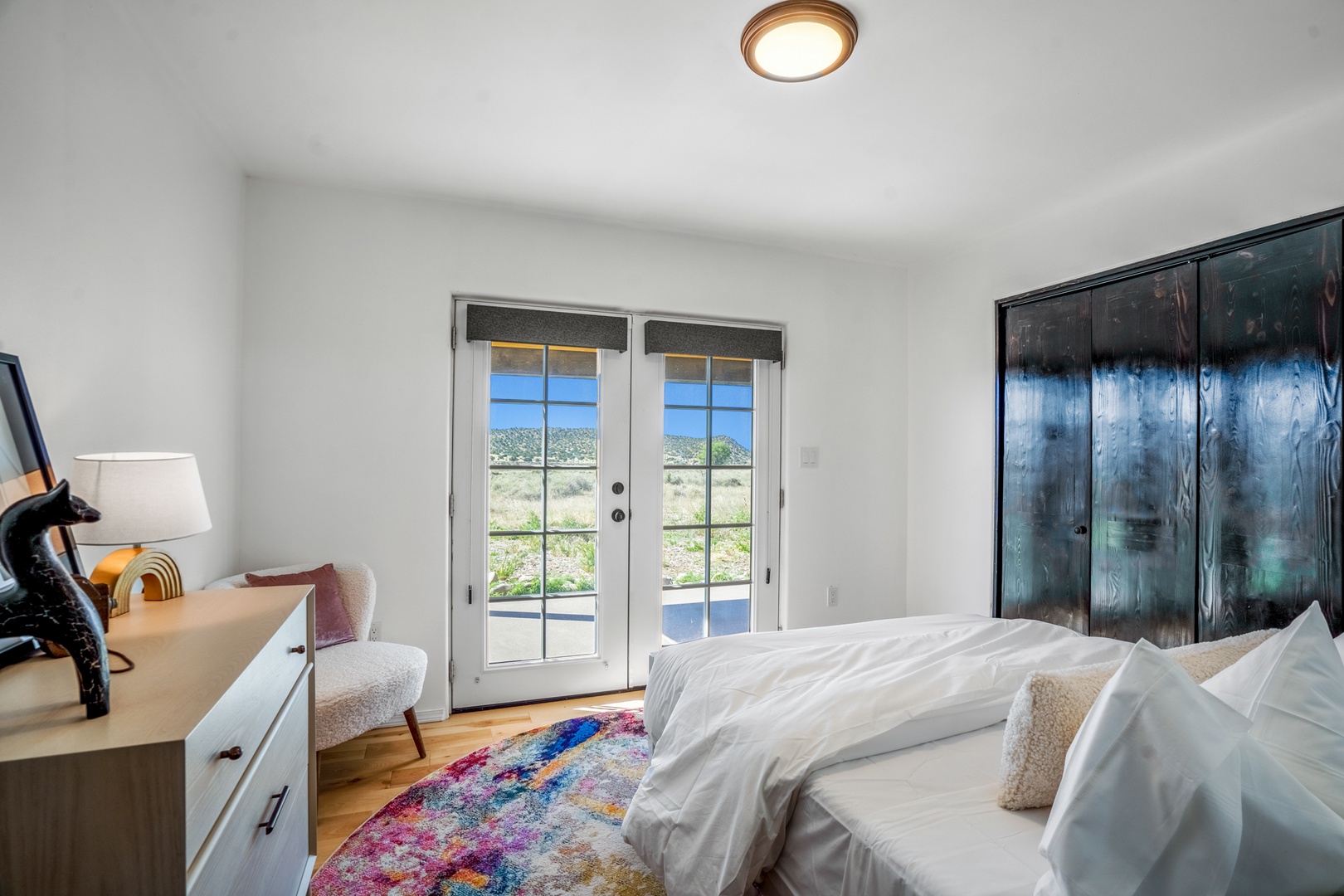 Drift off in your serene bedroom with stunning natural views through glass doors and contemporary artistic touches.