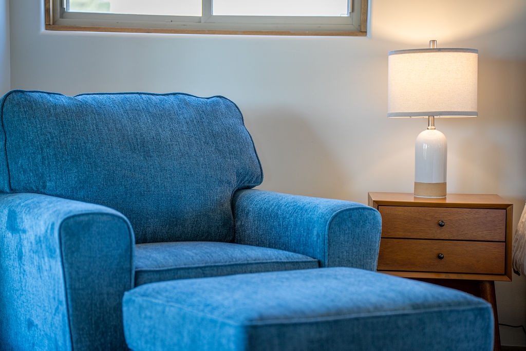 Sink into this plush blue armchair with its matching ottoman, perfect for your morning coffee or evening read by warm lamplight.