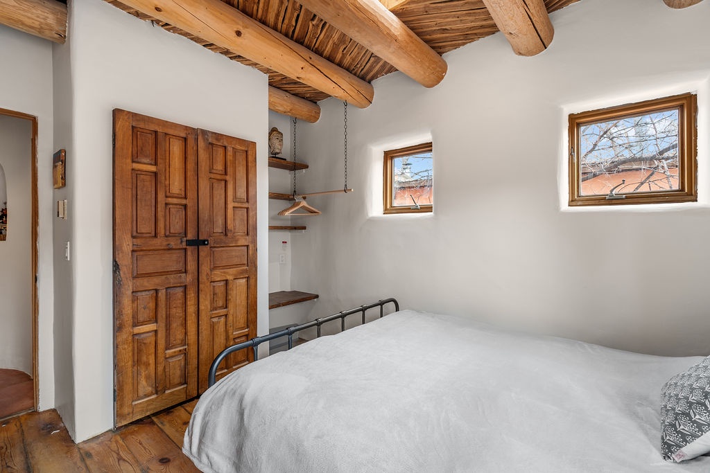 Drift off beneath rustic wooden beams in your serene bedroom, where charming details and peaceful mountain views create perfect sanctuary.
